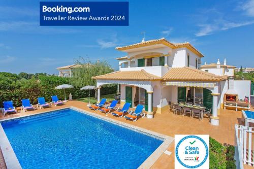 a villa with a swimming pool in front of a house at Villa White Sands - Private Oasis, Heated Pool, Beaches & Strip Nearby in Albufeira