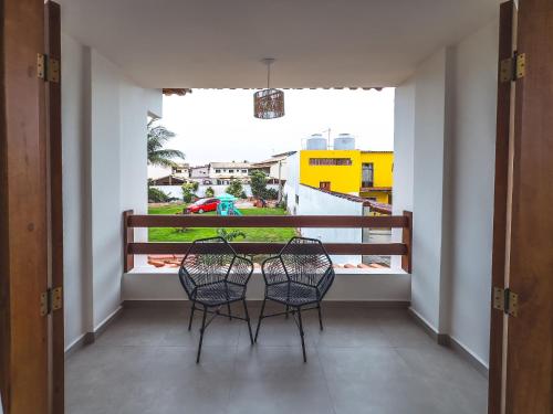 a balcony with two chairs and a table on a balcony at Casa Dela Pousada in Cabo Frio