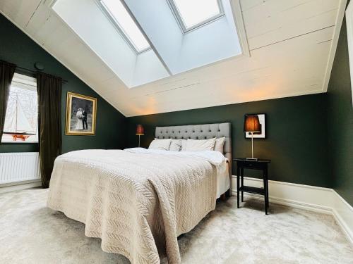 a bedroom with a large bed with a skylight at Stor villa i centrala Trosa intill Trosa ån och havet in Trosa