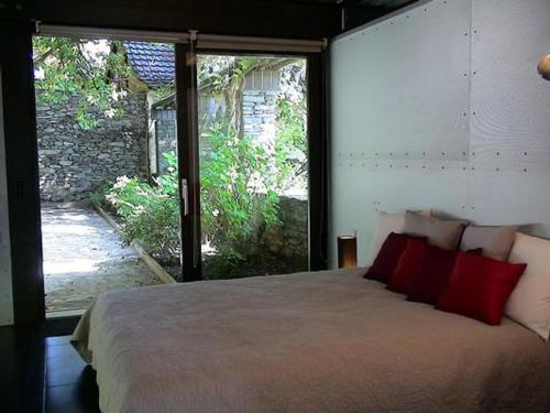 1 dormitorio con 1 cama grande con almohadas rojas en Villa Mappina Roccabella, en Locarno