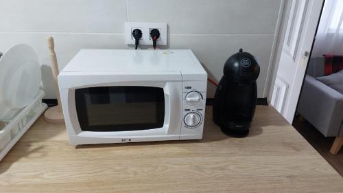 a microwave oven sitting on the floor next to a helmet at Apartamento cerca de la playa in Vinarós