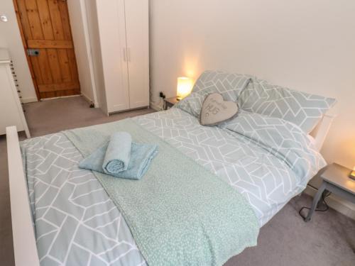 a bedroom with a bed with two towels on it at Rosewood Cottage in Durham