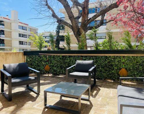 - une terrasse avec 2 chaises et une table basse dans l'établissement L’Écrin, à Aix-en-Provence