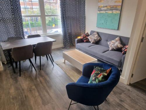 a living room with a couch and a table at Richmond Apartments in London
