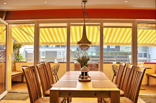 a dining room with a wooden table and chairs at neyland apartments Norderney in Norderney
