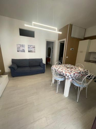 ein Wohnzimmer mit einem Tisch, Stühlen und einem Sofa in der Unterkunft ..A DUE PASSI DAL MARE in Terrasini