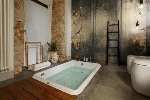 a bathroom with a bath tub and a toilet at Embrace Sicily Guest House in Noto