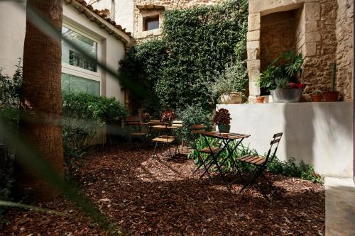 a patio with tables and chairs next to a building at Embrace Sicily Guest House in Noto