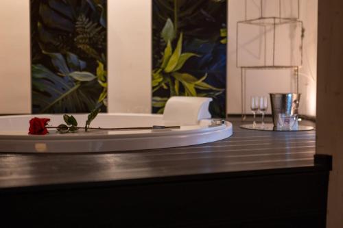 una mesa con dos vasos y una flor en ella en Suite Home3 beb, en Bisceglie