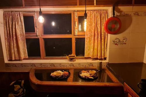 una cucina con due piatti di cibo su un lavandino di Gharsa - Your Mountain Home a Manāli