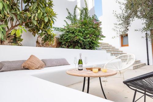a patio with a white couch and a table with a bottle of wine at Hostal Aljibe in Archidona