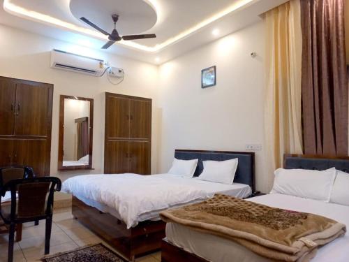 a hotel room with two beds and a chair at Kalash Guest House in Ayodhya