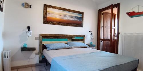 - une chambre avec un lit et une photo sur le mur dans l'établissement Casa vacanza Belvedere, à Torre Dei Corsari