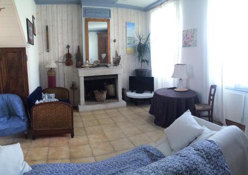 un salon avec un canapé et une cheminée dans l'établissement ile de Ré maison, à La Couarde-sur-Mer