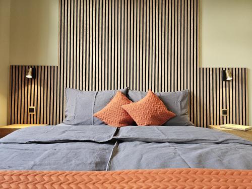 Una cama con almohadas de color naranja y azul. en Ferienhof SchilfMeer - Fewo "Seepferdchen", en Dorf Körkwitz