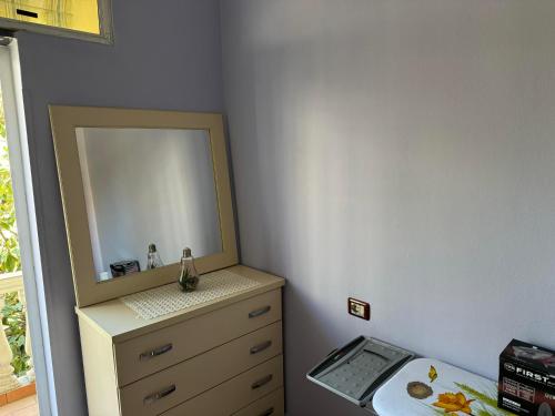 1 dormitorio con tocador y espejo en Moonlight Apartment, en Shkodër