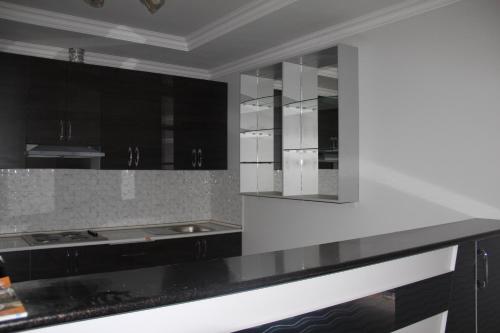 a kitchen with black cabinets and a white counter top at Hostel Asham in Panjakent