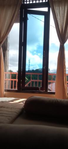 a bedroom with a window with a view of a balcony at Toraja Bungin Homestay in Rantepao