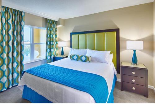 1 dormitorio con 1 cama grande y cabecero azul y verde en Be Our Silver Guest en Orlando