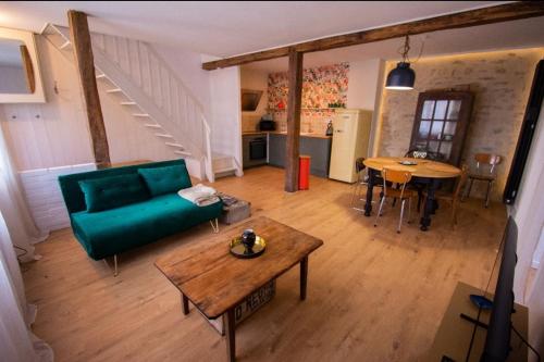 a living room with a green couch and a table at Maisonbroca in Bourges