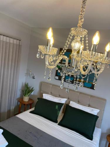 a bedroom with a large bed with a chandelier at Pousada Solar Mestre Propício in Pirenópolis