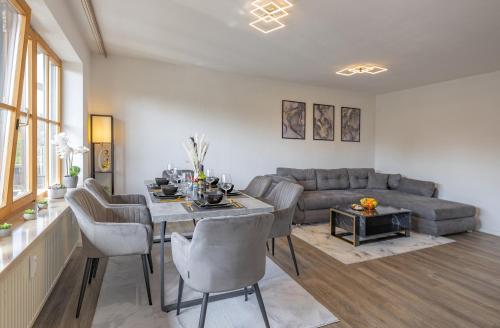 ein Wohnzimmer mit einem Tisch und einem Sofa in der Unterkunft DREAM - Alpenblick, Balkon, Hängematte, Parkgarage in Kolbermoor