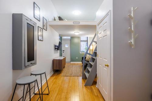 a hallway with two stools and a tv and stairs at Ultimate Urban living at Centrally Located Lofts in New York