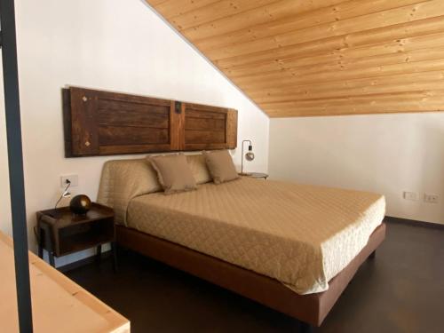 a bedroom with a large bed with a wooden headboard at Dalù houses in Tirano