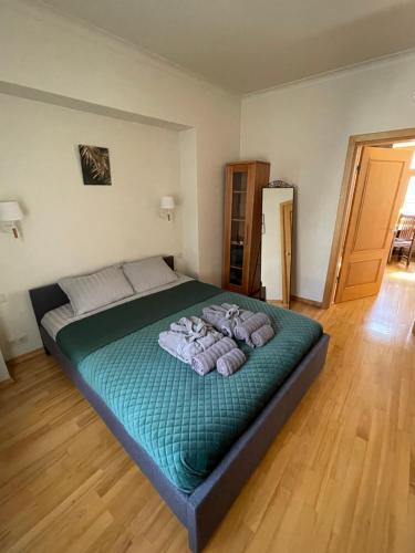 a bedroom with a large green bed with three pillows at Old City Harmony Apartment in Riga