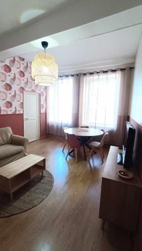 een woonkamer met een bank en een tafel bij Terre de Bourgogne - Appartement au centre ville d'Avallon in Avallon