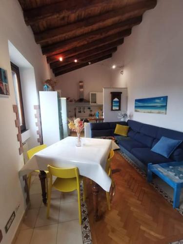 sala de estar con mesa y sofá azul en Casetta panoramica Ariccia, en Ariccia