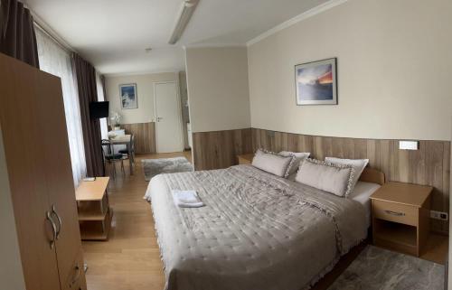 a bedroom with a bed and a living room at Apartments Weintrauben in Pärnu