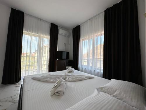 a hotel room with a bed with towels on it at Casa Roma in Mamaia Nord