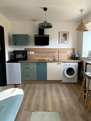 une cuisine avec un évier et une machine à laver dans l'établissement Entre ville et campagne appartement cosy avec parking et terrasse Wood, à Coutiches