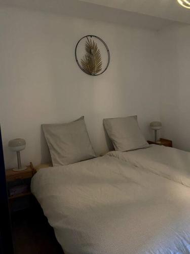 - un lit avec 2 oreillers et un miroir mural dans l'établissement Entre ville et campagne appartement cosy avec parking et terrasse Wood, à Coutiches