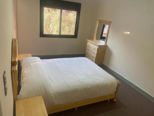 a bedroom with a bed and a dresser and a window at Chez azrou in Azrou