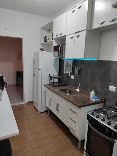a kitchen with white cabinets and a sink and a stove at Cantinho 31 de Março in São José dos Campos