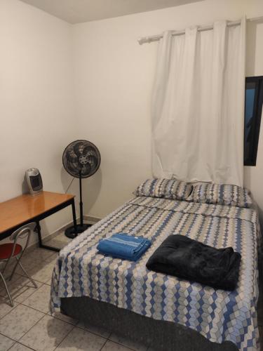 1 dormitorio con cama, escritorio y ventana en Cantinho 31 de Março, en São José dos Campos