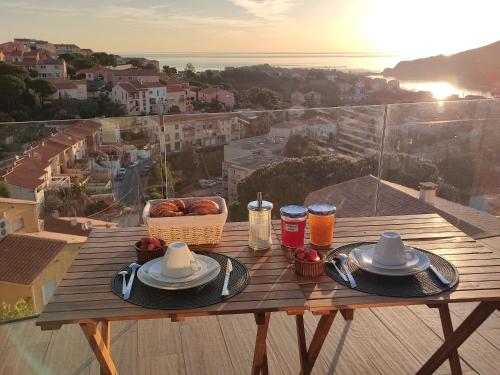 a table with plates of food and a basket of bread at La sentinelle du cap Bear in Port-Vendres