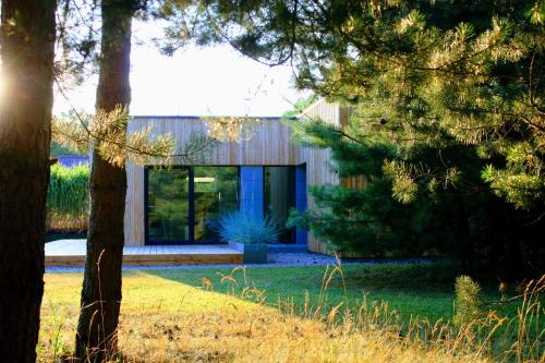 a house in a garden with trees in the foreground at Panorama Podlasie Home&SPA in Czyże