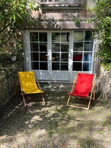 two chairs sitting in front of a window at Studio pleine nature in Le Vésinet