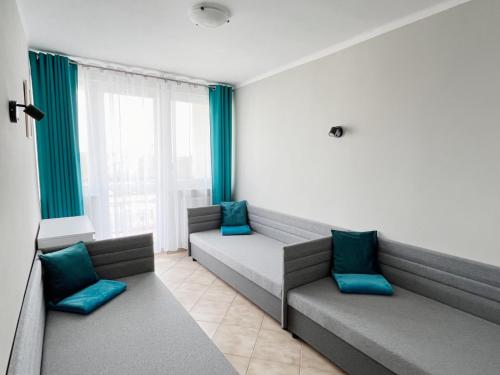 a waiting room with couches and blue pillows at Apartament "Na fali" in Jarosławiec