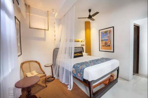 a bedroom with a bed and a chair in it at Queen of Galle in Galle