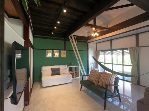 a bedroom with green walls and a bed and a chair at Onjuku海岸Hana House Private Villa 1 minutes from the beach in Onjuku
