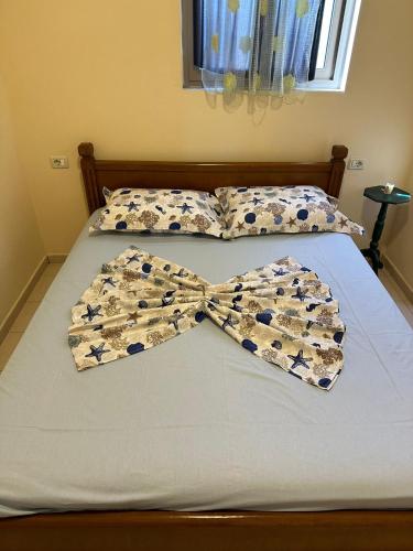 un letto con un papillon sopra di Hotel Clarissa a Velipojë