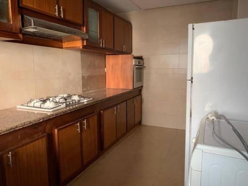 ラバトにあるBeautiful 3BR apartment in Hay Riad Rabatのキッチン(木製キャビネット、コンロ付)