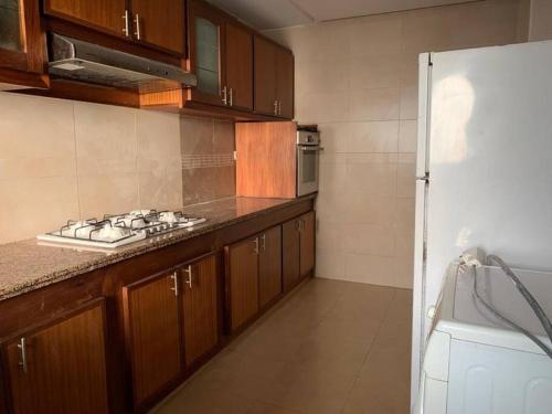 Una cocina con gabinetes de madera y un horno de estufa. en Beautiful 3BR apartment in Hay Riad Rabat, en Rabat