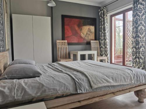 a bedroom with a bed and a table and chairs at Poza Zgiełkiem in Węgorzewo