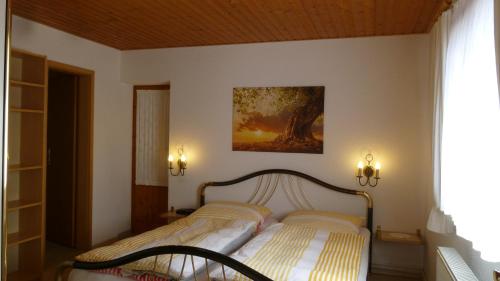 戈里施水療的住宿－Ferienwohnung Frenzel，卧室配有一张床,墙上挂有绘画作品