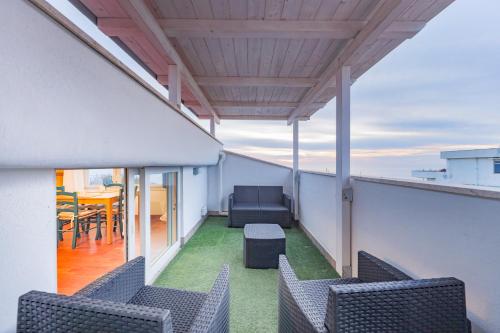 a balcony with chairs and a table on a roof at Orizzonte in blu in Anzio